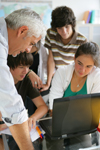 Adolescents devant un ordinateur portable pr�s d'un homme � aure